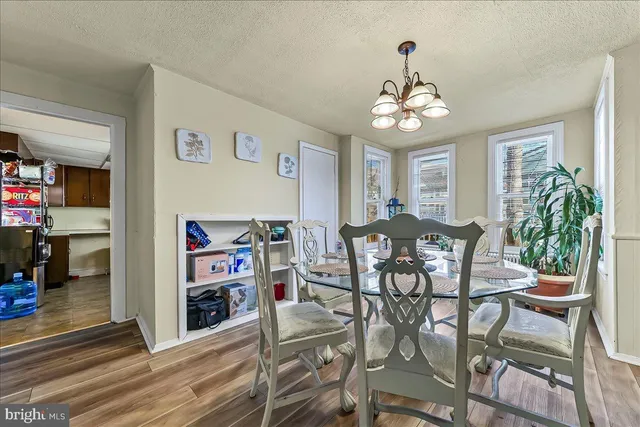 a view of a dining room with furniture a chandelier and wooden floor