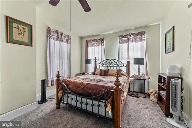 a bedroom with a bed a table and painting on the wall