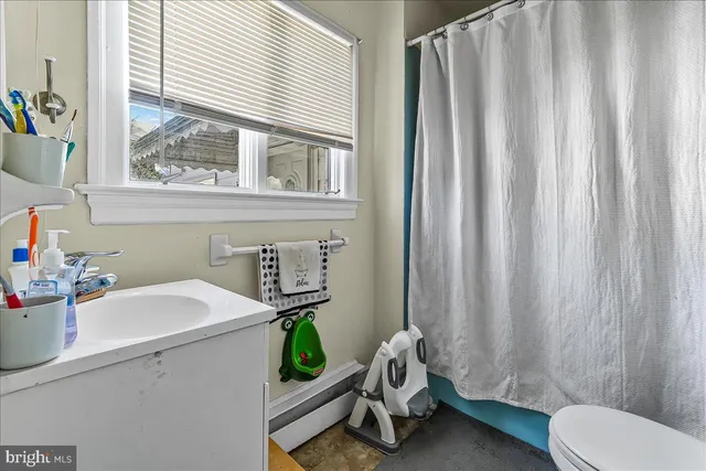 a bathroom with a sink a toilet and a window