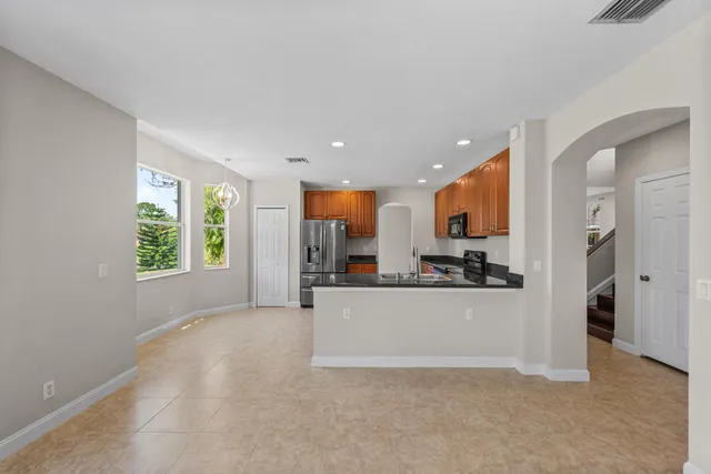 a view of a kitchen with kitchen island a sink wooden floor and a refrigerator