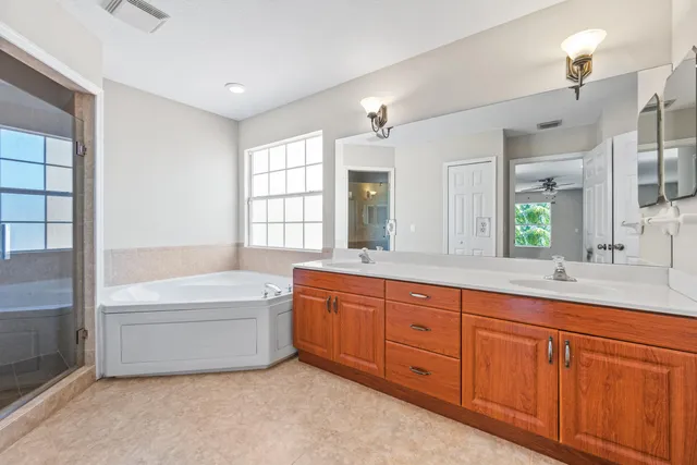 a bathroom with a tub sink shower double vanity