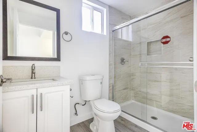 a bathroom with a granite countertop sink toilet a shower and a mirror