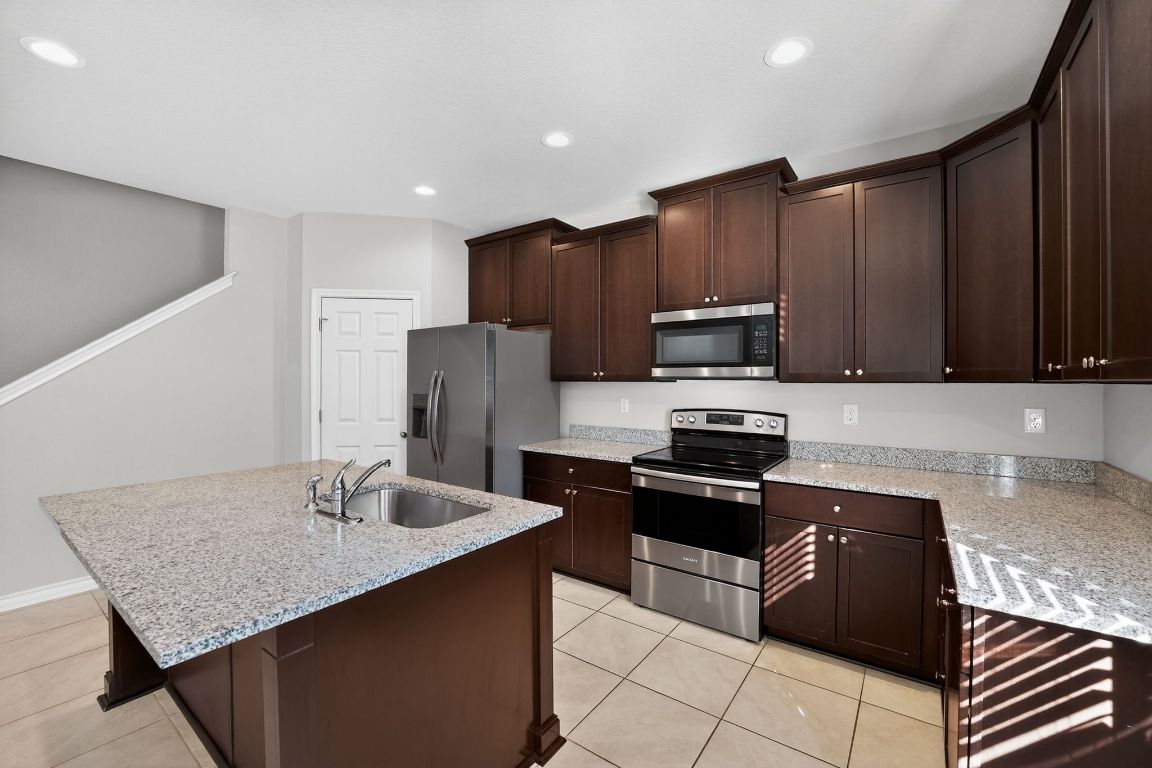 548 Appalachian Trail Leander, TX 78641 - Photo 14 of 38 a kitchen with stainless steel appliances granite countertop a sink stove and refrigerator