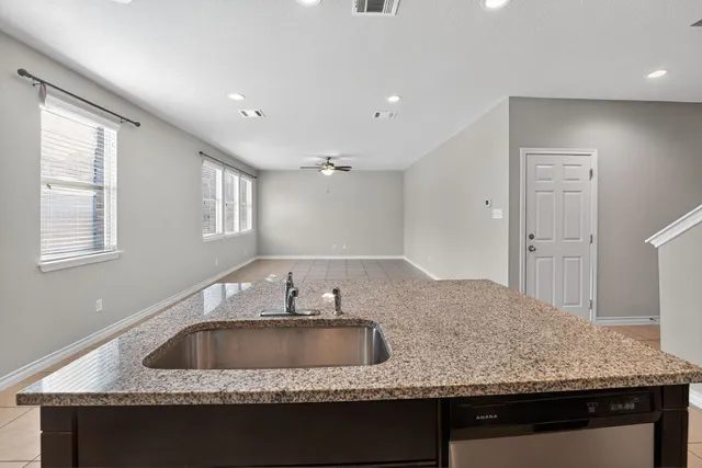 a kitchen with granite countertop a sink a counter and window