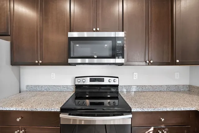 a kitchen with granite countertop cabinets and steel stainless steel appliances