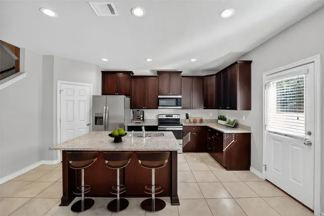 a kitchen with stainless steel appliances granite countertop a refrigerator stove a sink and a microwave