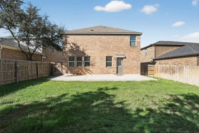 a view of a house with backyard and a patio