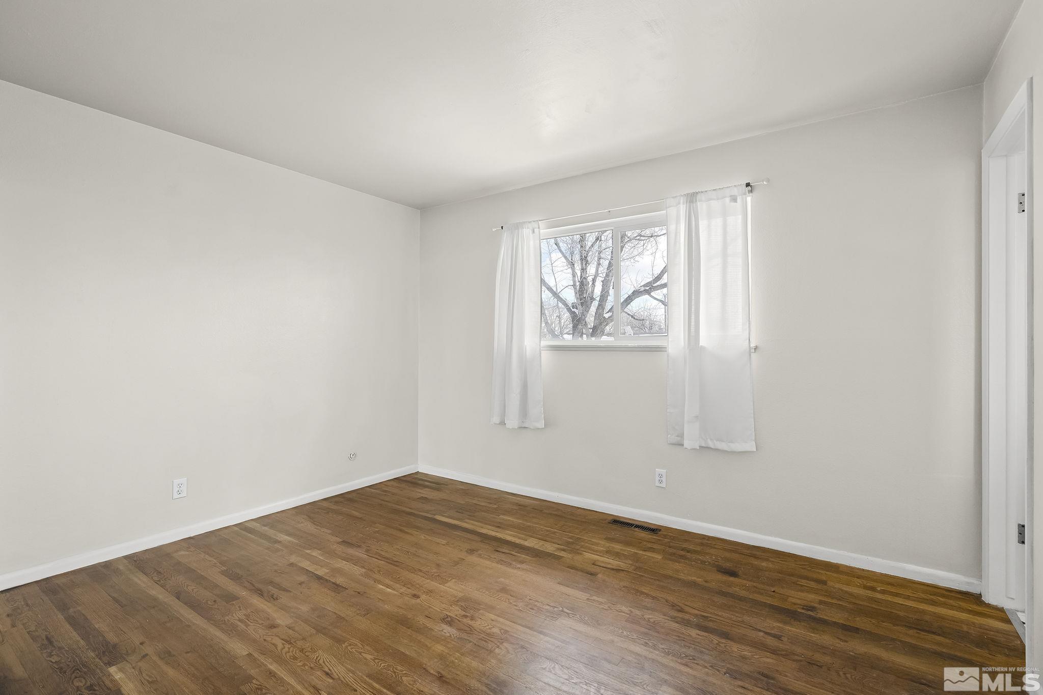 3475 Rauscher Drive Reno, NV 89503 - Photo 13 of 16 an empty room with wooden floor and windows