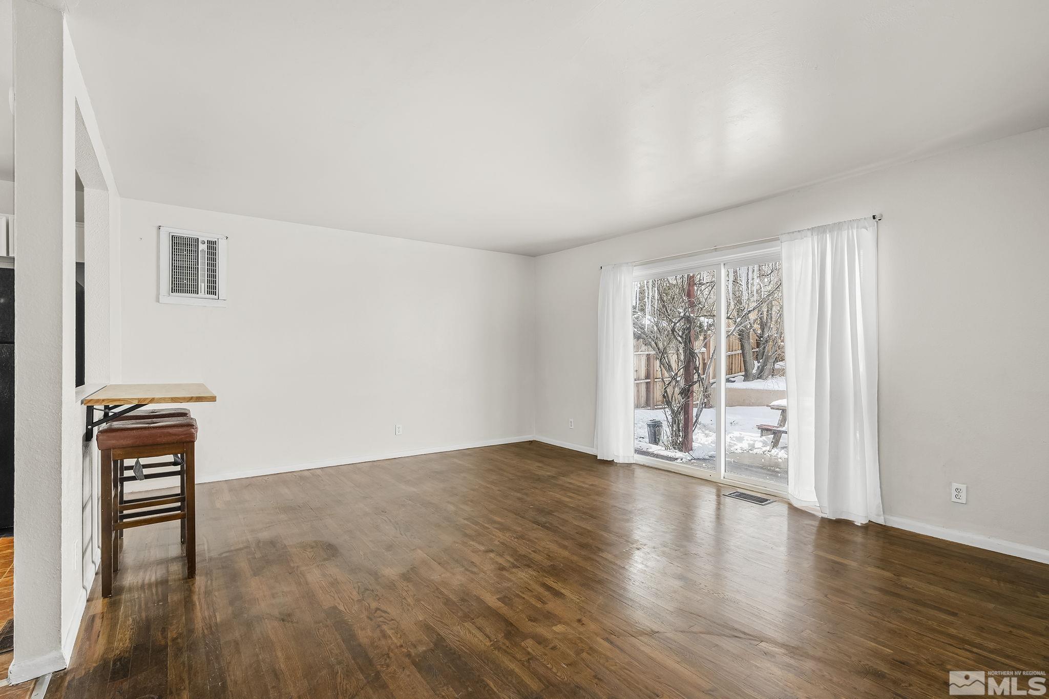 3475 Rauscher Drive Reno, NV 89503 - Photo 3 of 16 a view of an empty room with wooden floor and a window