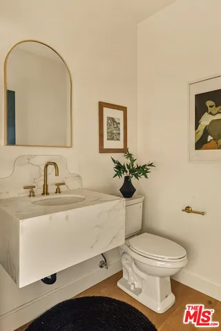 a bathroom with a toilet a sink and mirror