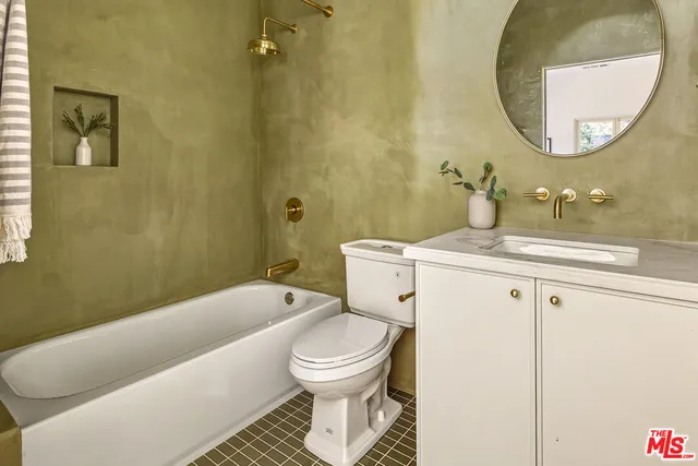 a bathroom with a sink a toilet and a mirror