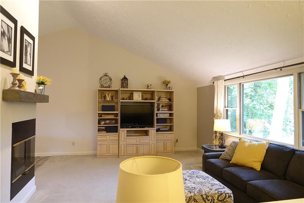 133 Isle Road Butler, PA 16001 - Photo 3 of 25 Living room with 3 way gas fireplace, vaulted ceiling, and newer carpeting