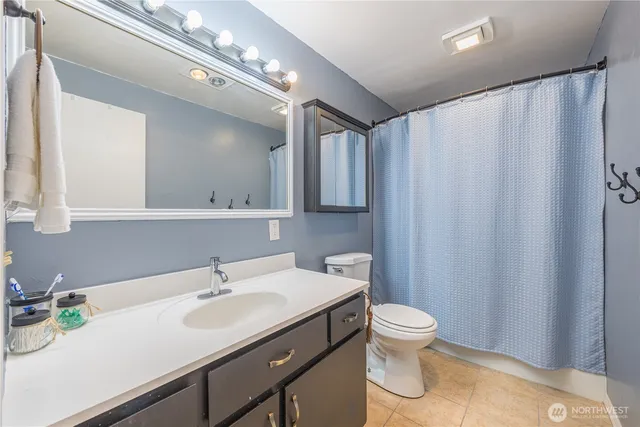 a bathroom with a sink a toilet and mirror