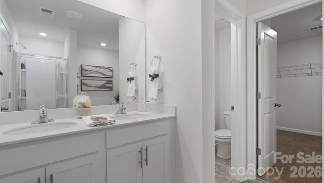 a bathroom with a granite countertop sink a toilet and a mirror