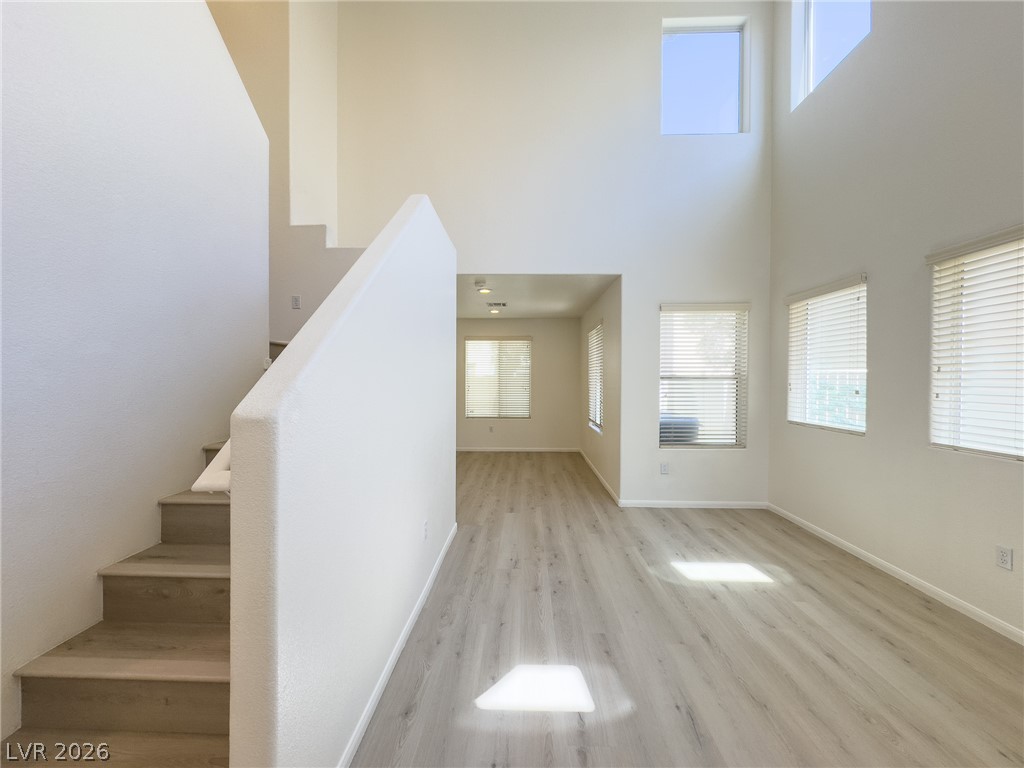 9456 Grandview Spring Avenue Las Vegas, NV 89166 - Photo 3 of 49 Natural light floods this living area, highlighting high ceilings and durable flooring.