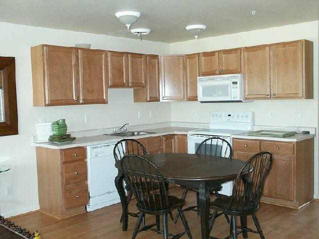 712 Lakeside Drive Basalt, CO 81621 - Photo 6 of 7 a kitchen with granite countertop a dining table chairs and a refrigerator