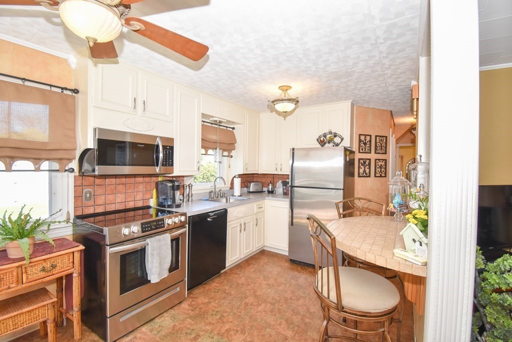 276 Oak Street Springfield, MA 01151 - Photo 6 of 36 a kitchen with stainless steel appliances granite countertop a stove top oven a sink and a microwave