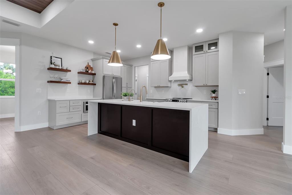 776 Cypress Road Venice, FL 34293 - Photo 2 of 89 a open kitchen with kitchen island a sink dishwasher a stove and a refrigerator with wooden floor