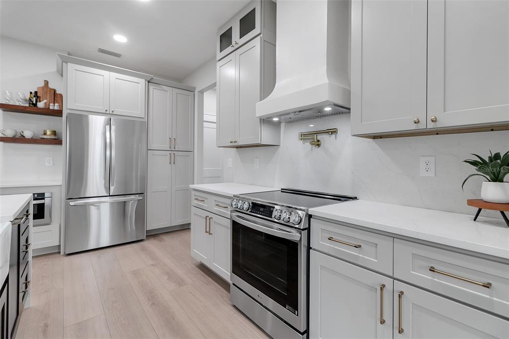 776 Cypress Road Venice, FL 34293 - Photo 28 of 89 a kitchen with stainless steel appliances white cabinets and a stove top oven