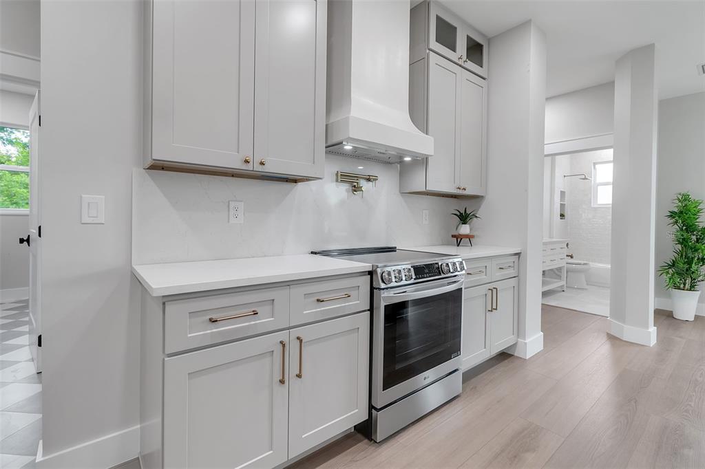 776 Cypress Road Venice, FL 34293 - Photo 36 of 89 a kitchen with stainless steel appliances white cabinets and a stove a oven with wooden floors