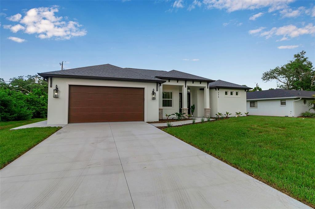 776 Cypress Road Venice, FL 34293 - Photo 7 of 89 a front view of a house with a yard and garage