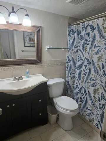 a bathroom with a sink toilet and mirror