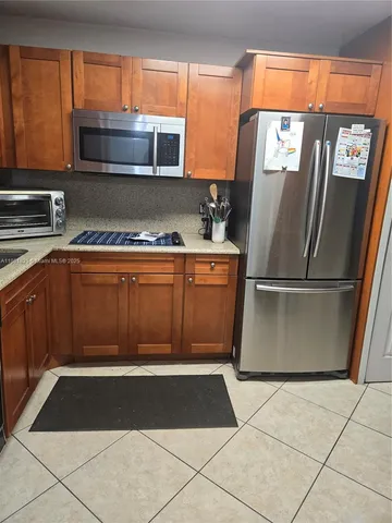 a kitchen with a refrigerator and a stove top oven