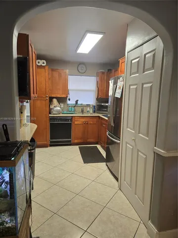 a kitchen with granite countertop a refrigerator and a sink