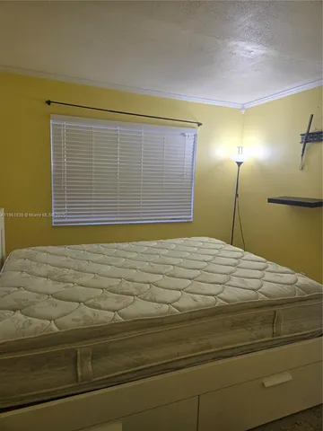 a bed sitting in a bedroom next to a window