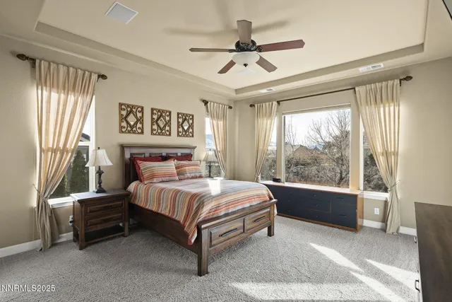 a living room with a bed furniture flat screen tv and a large window