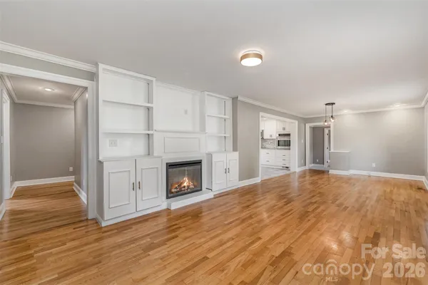 a view of empty room with wooden floor and fireplace