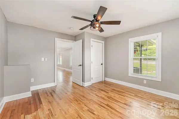 a view of a livingroom with a ceiling fan and wooden floor