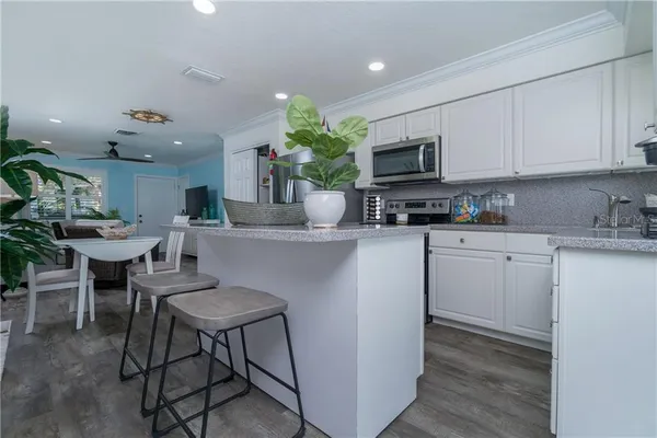 a kitchen with a sink cabinets and wooden floor