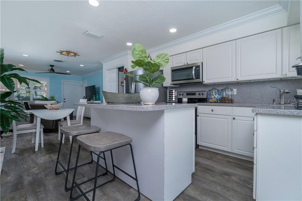 5041 North Beach Road, Unit 3A Englewood, FL 34223 - Photo 12 of 52 a kitchen with a sink cabinets and wooden floor