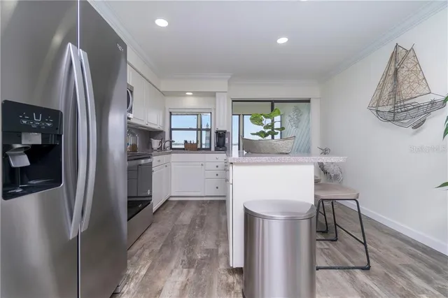 a kitchen with stainless steel appliances a refrigerator sink and wooden floor