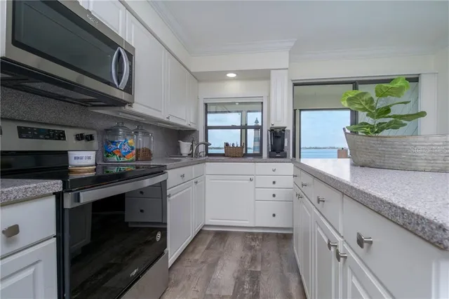 a kitchen with stainless steel appliances granite countertop a sink a stove and cabinets