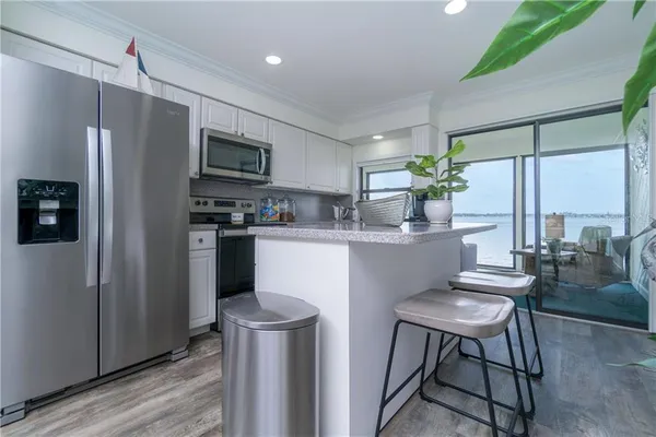 a kitchen with kitchen island a appliances a counter space and a refrigerator