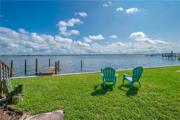a view of a lake with table and chairs