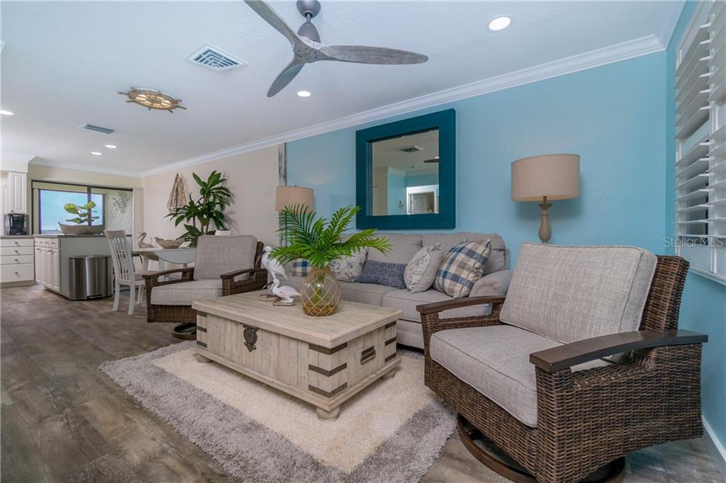 5041 North Beach Road, Unit 3A Englewood, FL 34223 - Photo 6 of 52 a living room with furniture potted plant and a lamp