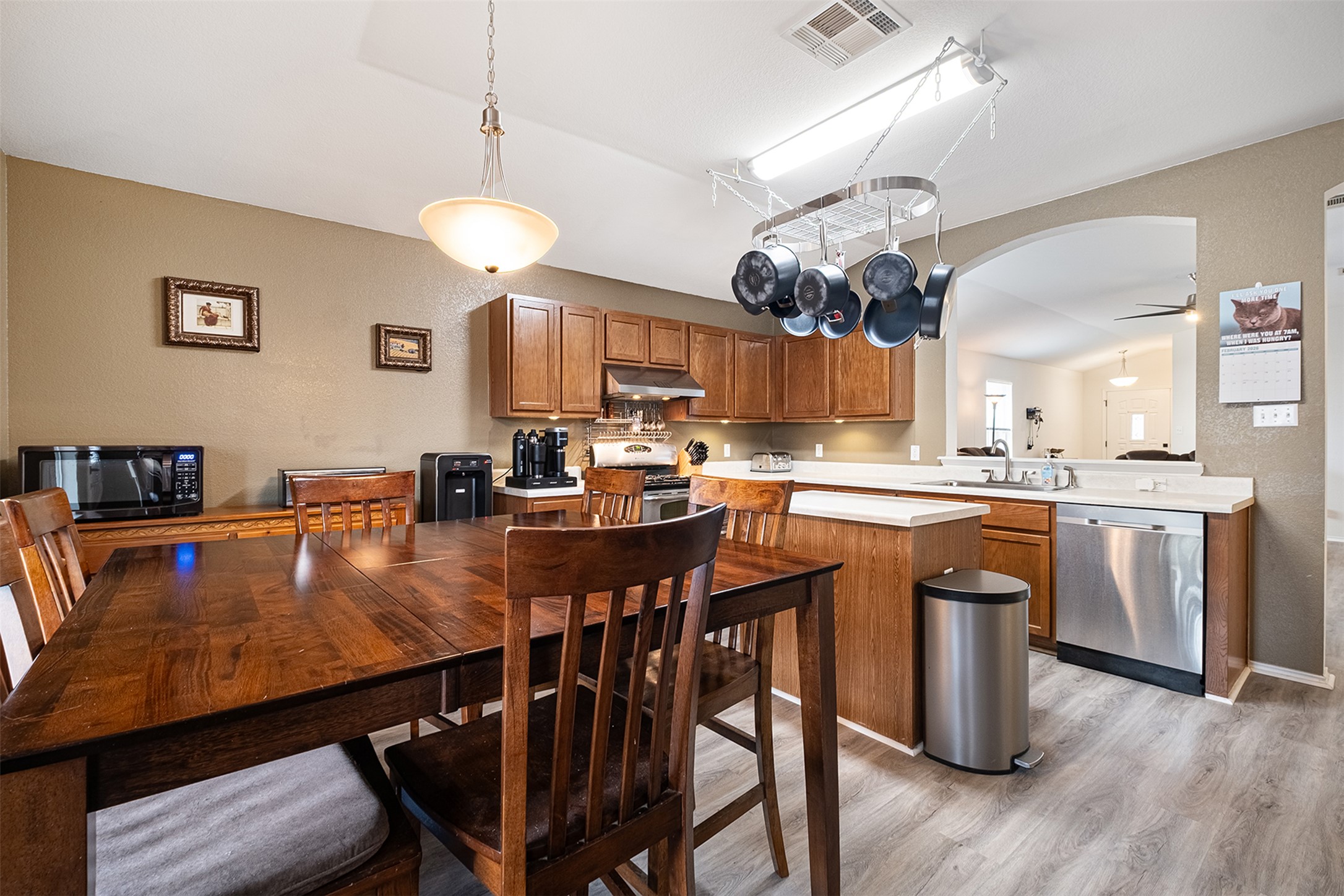 745 Caylor Cove Bastrop, TX 78602 - Photo 13 of 38 a kitchen with stainless steel appliances granite countertop a stove a sink dishwasher a dining table and chairs with wooden floor