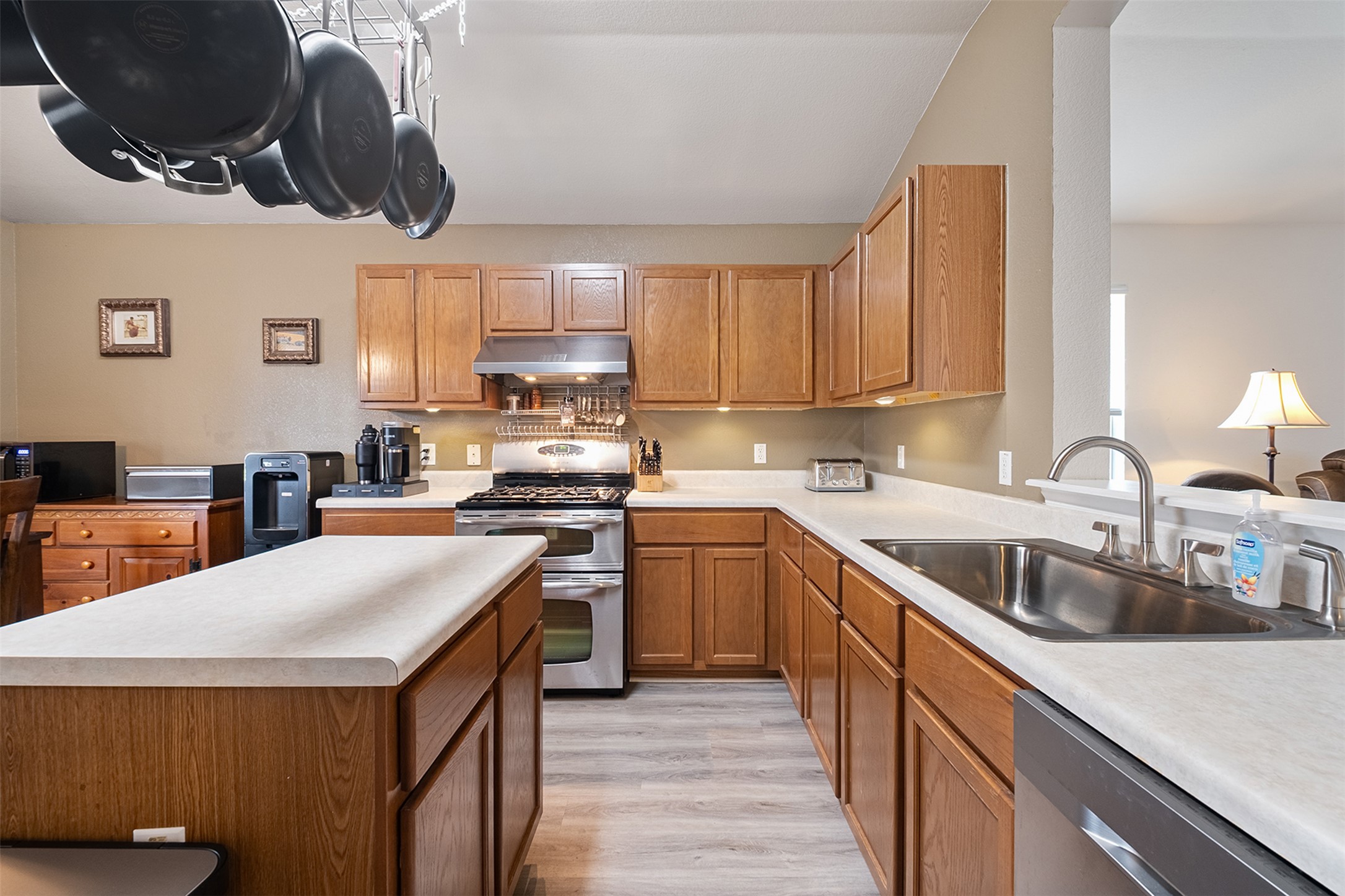 745 Caylor Cove Bastrop, TX 78602 - Photo 14 of 38 a kitchen with a sink dishwasher a stove top oven a washer dryer and cabinets