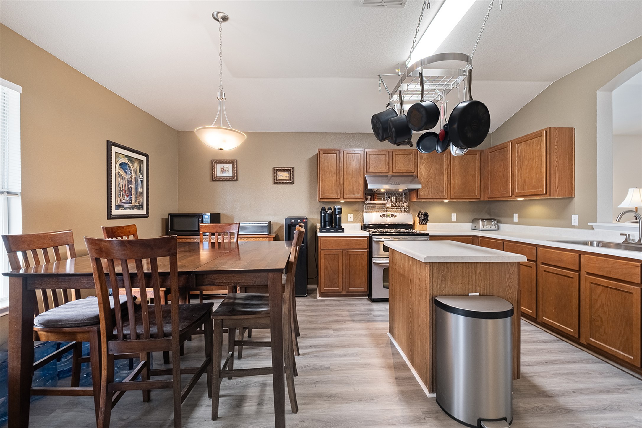 745 Caylor Cove Bastrop, TX 78602 - Photo 16 of 38 a kitchen with stainless steel appliances granite countertop wooden floor a dining table and chairs