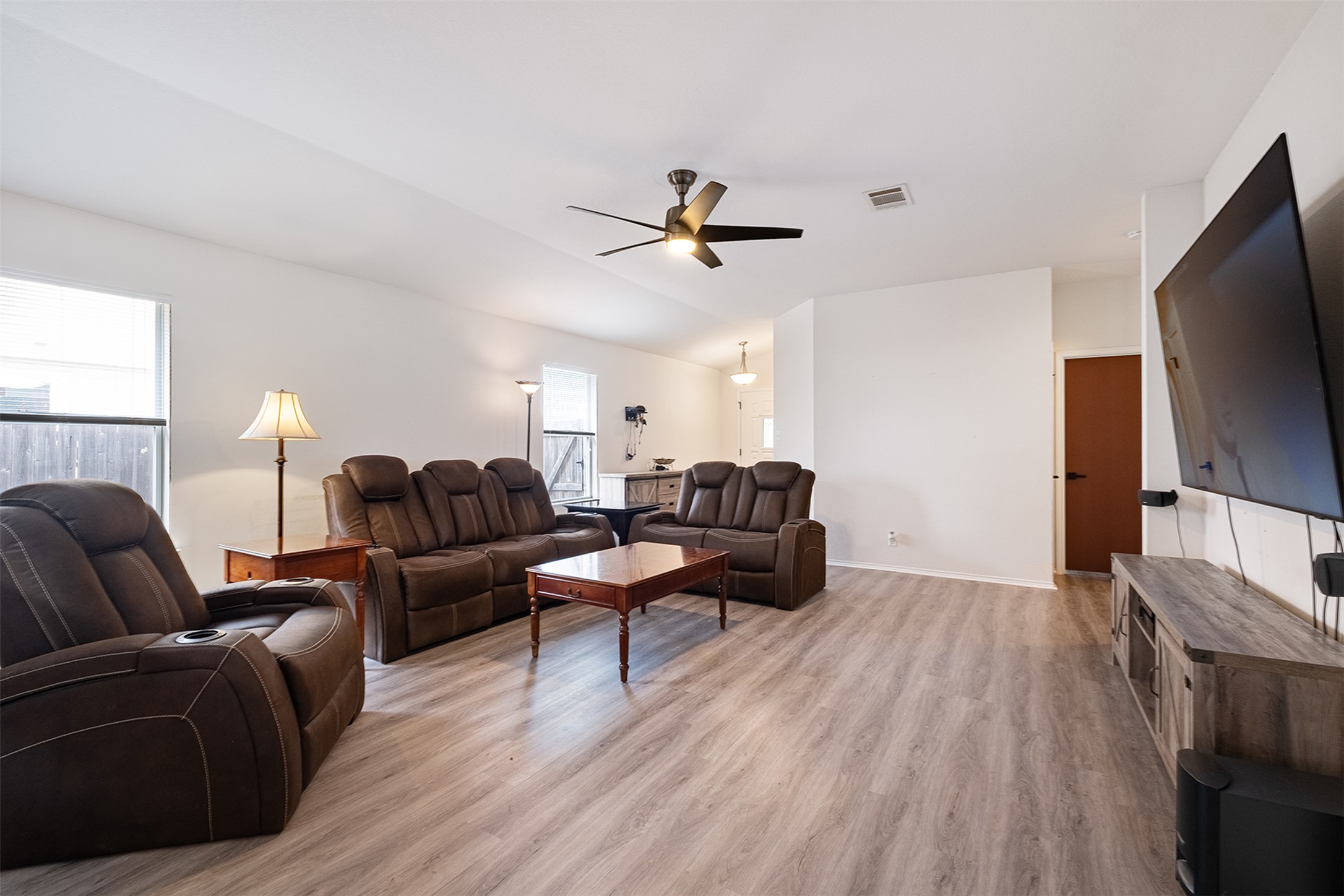 745 Caylor Cove Bastrop, TX 78602 - Photo 4 of 38 a living room with furniture a flat screen tv and a window