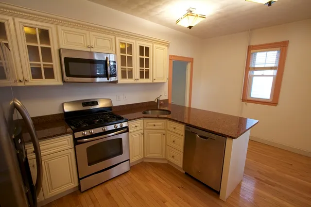 a kitchen with stainless steel appliances a stove microwave and sink