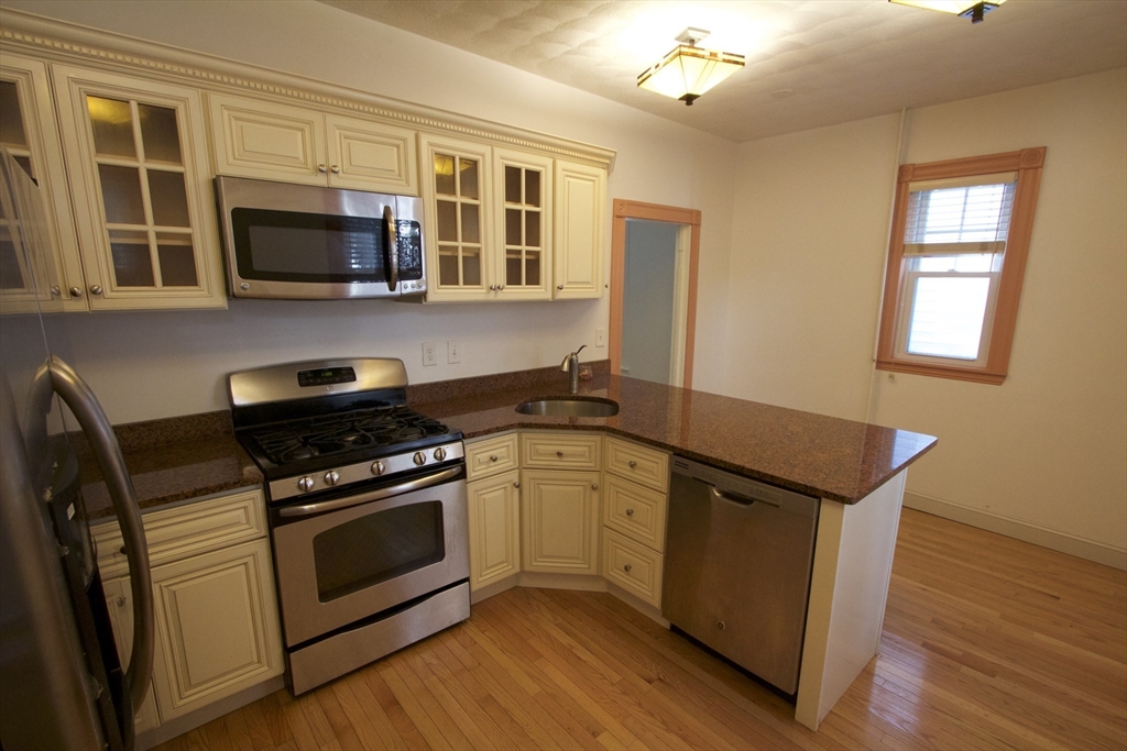 31 Dunreath Street, Unit 1 Boston, MA 02119 - Photo 2 of 11 a kitchen with stainless steel appliances a stove microwave and sink