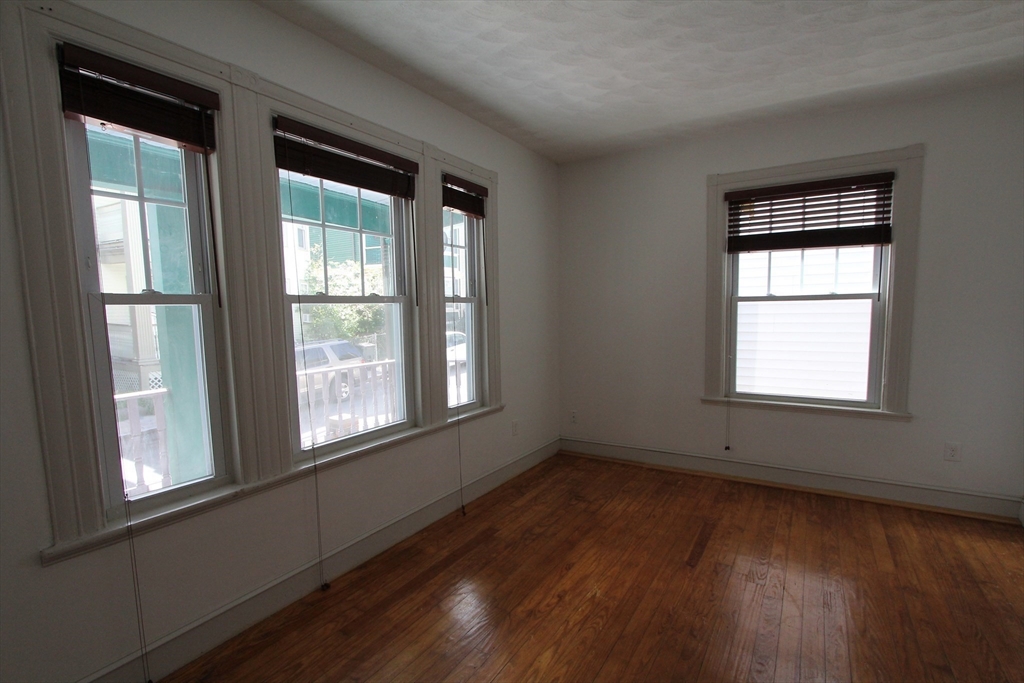 31 Dunreath Street, Unit 1 Boston, MA 02119 - Photo 5 of 11 a view of an empty room with wooden floor and a window