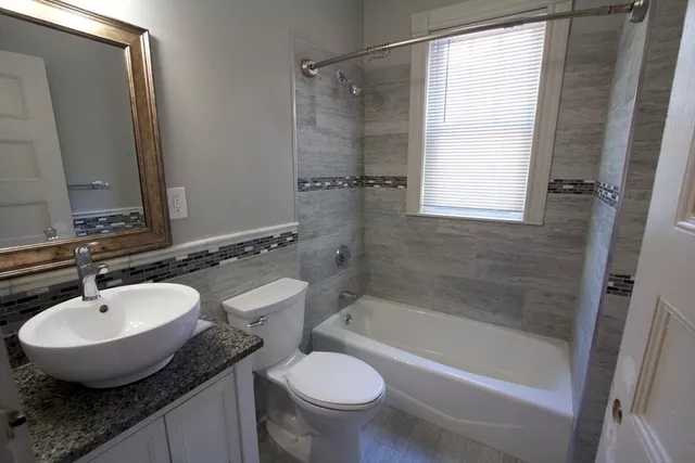 a bathroom with a granite countertop sink toilet and shower