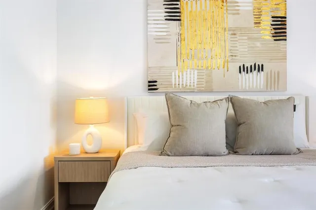 a bed sitting in a bedroom next to a window