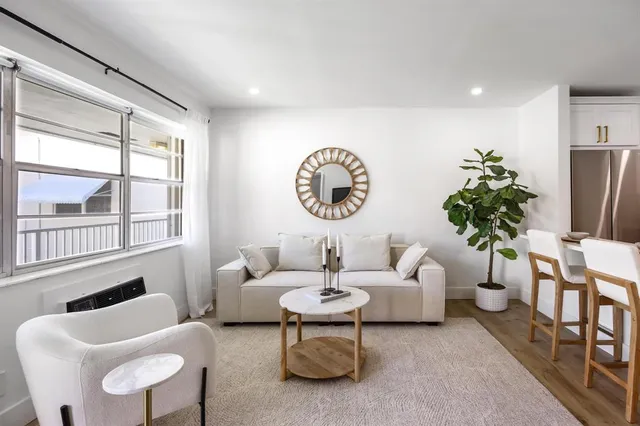 a living room with furniture a chandelier and a large window