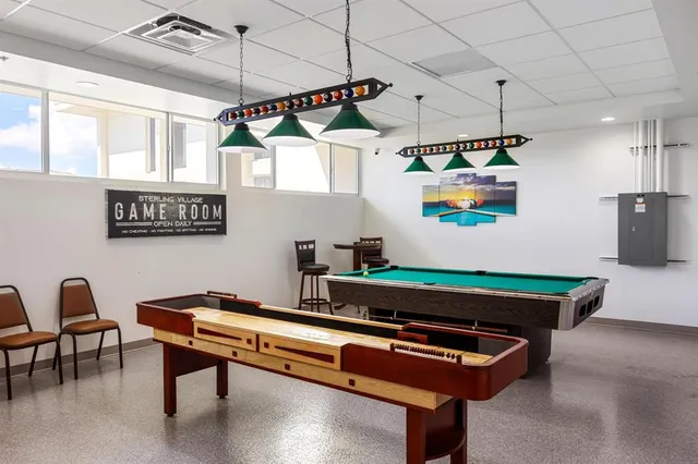 a room with furniture pool table and windows